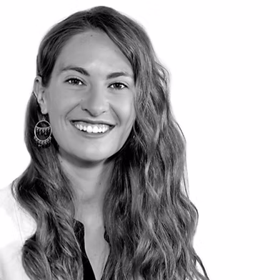 Smiling woman with long wavy hair and hoop earrings facing the camera.