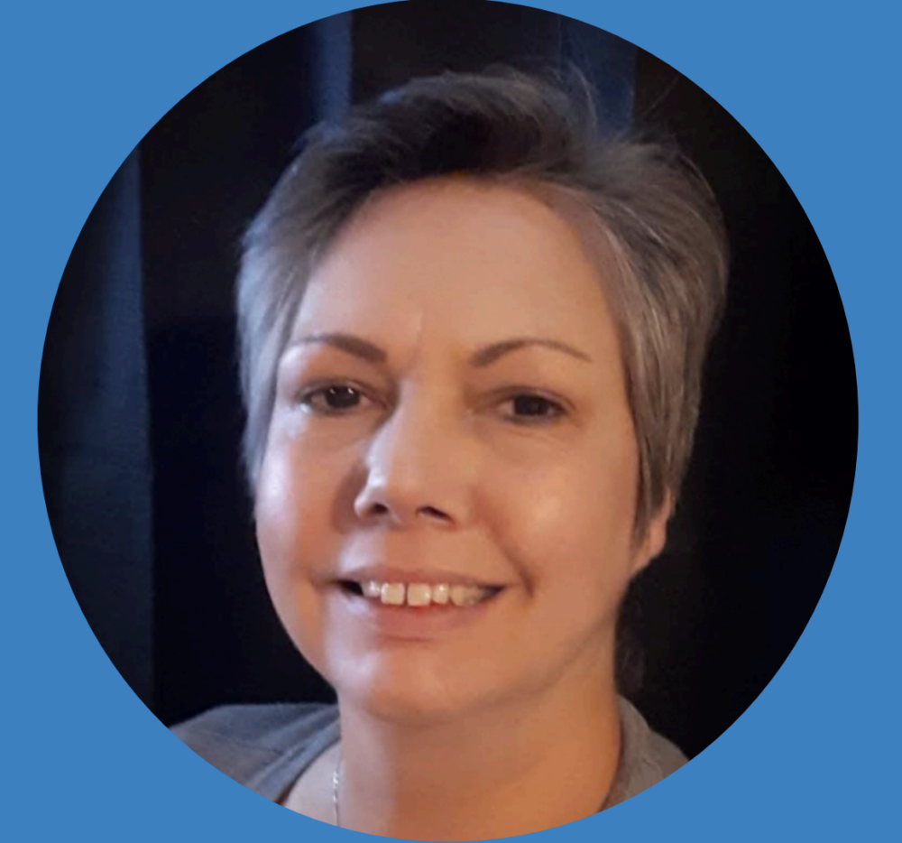Profile photo: smiling woman with short gray hair, set in a circular blue frame (avatar).